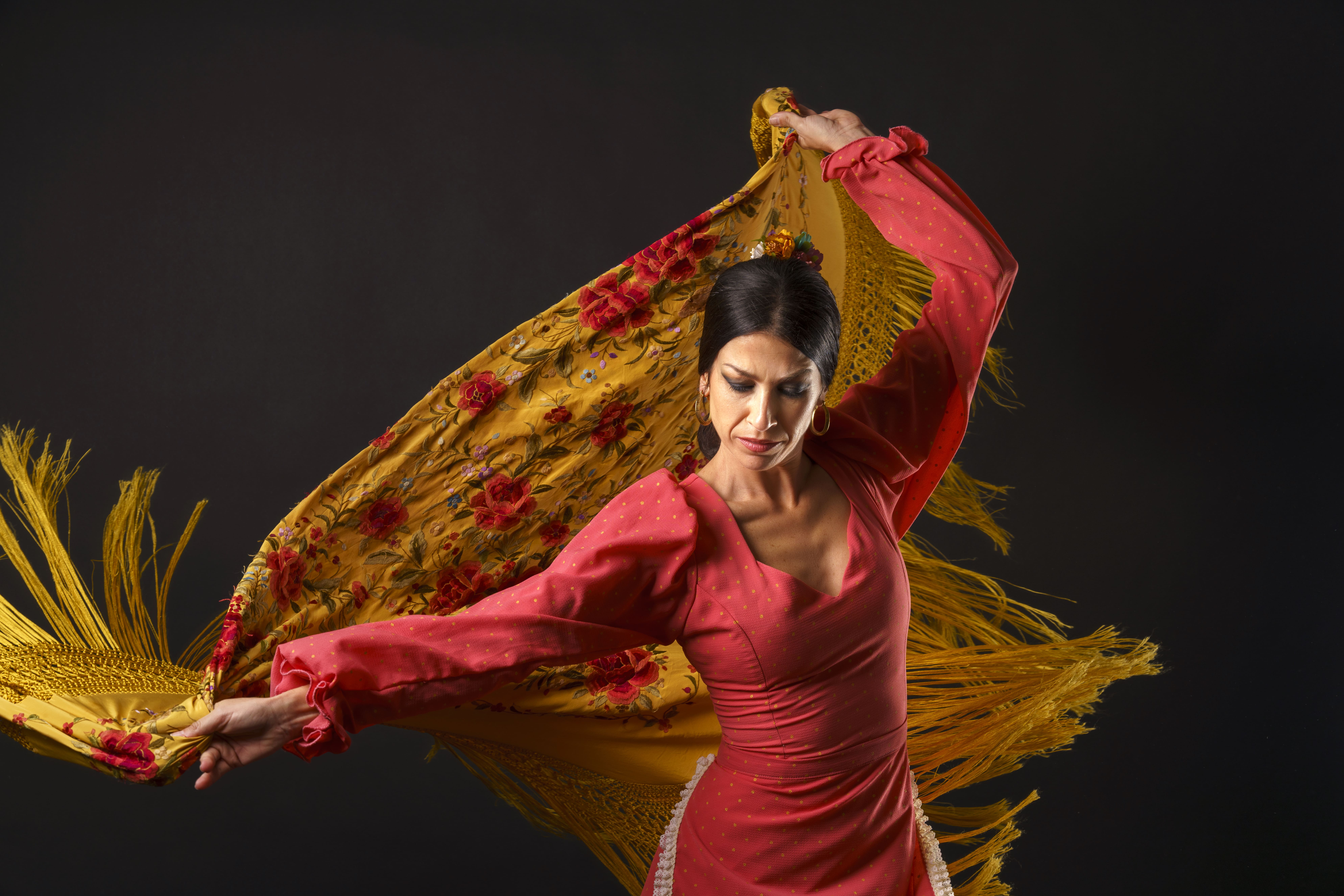 Grupo de artistas flamencos en Andalucía interpretando cante, toque y baile jondo en escenario típico andaluz
